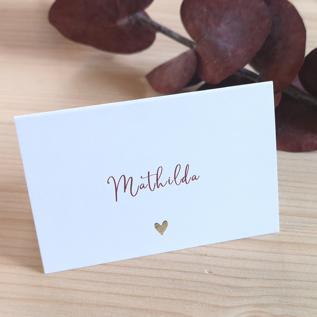 Tischkarte mit dem Namen Mathilda in Schreibschrift und kleinem goldenen Herzen